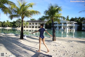 A woman in a polka dot swimsuit standing on a dock.