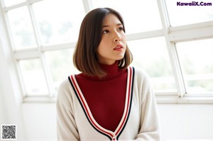 A woman in a red sweater and green plaid skirt posing for the camera.