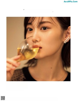 A woman sitting at a table with a glass of wine.