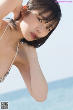 A woman in a bikini standing on the beach.