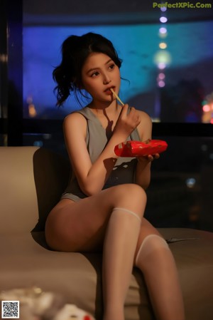 A woman in stockings and stockings sitting on a couch.