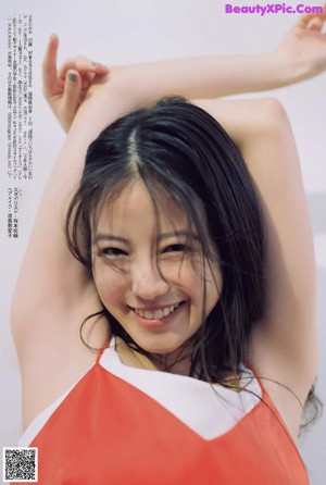 A young woman sitting at a table with her hand on her head.