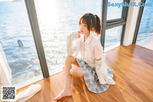 A woman laying on a wooden floor next to the ocean.