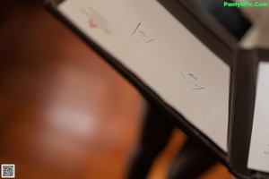 A woman sitting on a chair talking on a cell phone.