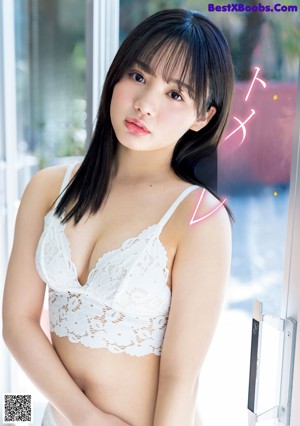 A woman in a white lingerie sitting on a blue couch.
