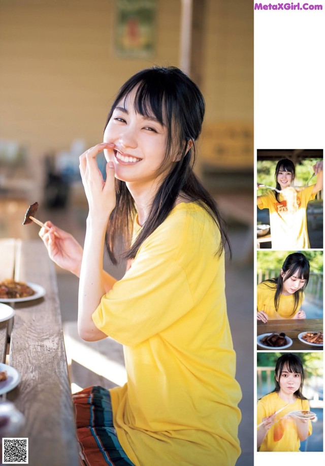 A woman sitting at a table eating a piece of food.