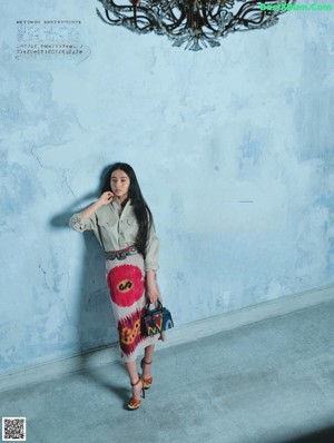 A woman standing in front of a blue door.