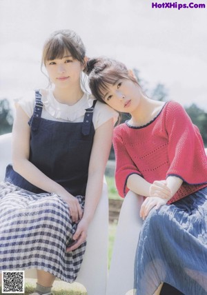 A couple of young women laying on top of a couch.