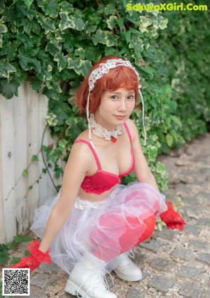 A naked woman in red stockings and white boots sitting on the floor.