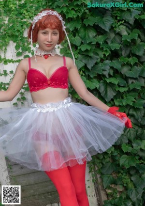 A woman in a red and white dress and red gloves.