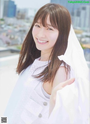 A woman with long brown hair is posing for a picture.