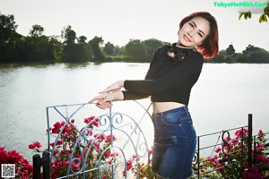 A woman leaning on a railing by the water.