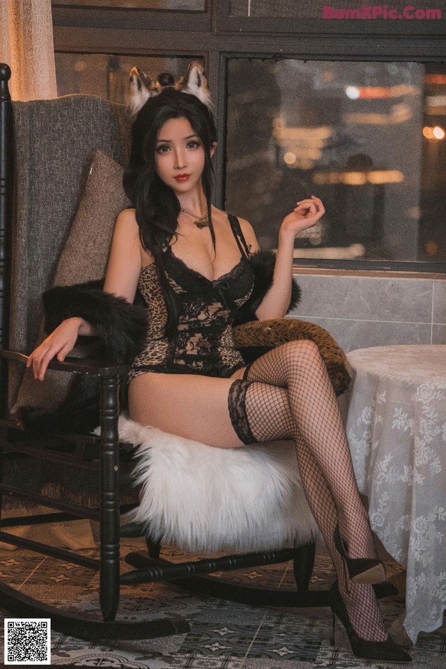 A woman sitting in a rocking chair wearing a leopard print lingerie.